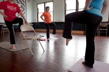 Lois Brenner of rural Randall, from left to right, Jean Clark of Little Falls, and instructor Kristie Roach move into tree pose during a yoga class on June 4, 2013. Yoga classes are held Tuesday and Thursday mornings in a second floor studio space at The Old Creamery Quilt Shop in Randall. The 1,200-square-foot room is used for classes and workshops and is also available for rent. (Ann Arbor Miller for MPR)